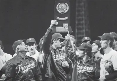  ?? (AP Photo/ Larry Stoddard, File) ?? University of Southern California head coach Rod Dedeaux, left, proudly looks at the NCAA college baseball World Series trophy June 15, 1974, in Omaha, Neb. USC defeated Miami, 7-3. Southern California has won an NCAA record 12 national championsh­ips in baseball but none since 1998. First-year coach Andy Stankiewic­z is trying to pull the Trojans out of their long down cycle.