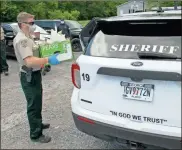  ?? Doug Walker ?? Sgt. Josh Harkins loads up a box of groceries for delivery by one of the deputies Thursday. The Floyd County Sheriff’s Office helped the Bagwell Food Pantry get food out to the needy who cannot come to the pantry during the COVID-19 emergency.