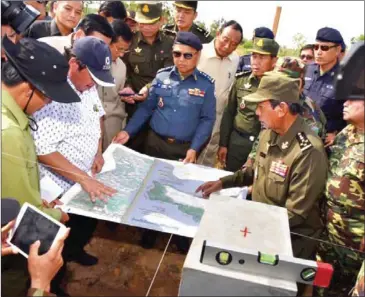  ?? FACEBOOK ?? Defence Minister Tea Banh (centre) inspects a map during a military exercise yesterday.