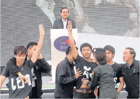  ?? CHANAT KATANYU ?? Dao Din students flashing a three-fingered salute against the coup as the prime minister gives a speech at Khon Kaen Town Hall in November last year.