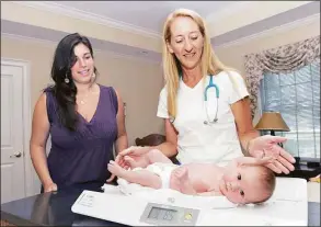  ?? Hearst Connecticu­t Media file photo ?? Catherine Parisi, right, weighs a one-month-old baby at The Connecticu­t Childbirth and Women’s Center in Danbury in 2011.