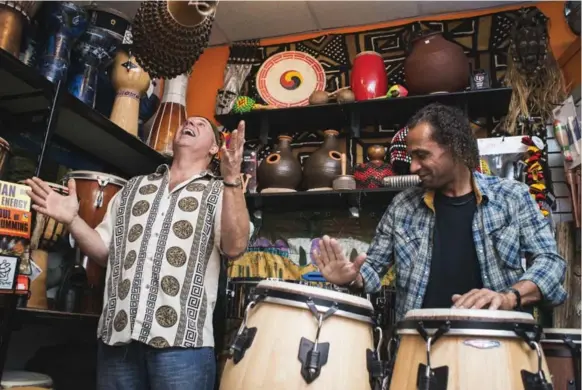  ?? BRIAN B. BETTENCOUR­T/TORONTO STAR ?? Soul Drums co-owner Doug Sole, left, demonstrat­es how to play a traditiona­l Cuban shekere alongside musician Altaf Bwana Motto Vellani on the congas.