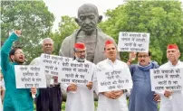 ?? PTI ?? MPs of Rashtriya Janata Dal, Samajwadi Party and Communist Party of India display placards and raise slogans during a protest over the recent incidents of Deoria, Bihar and Muzaffarpu­r shelter homes at Parliament House, in New Delhi on Tuesday. —
