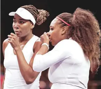  ?? PTI ?? USA’s Venus Williams (left) and Serena Williams talk between points during their doubles match against Netherland­s in the Fed Cup first round on Sunday. The hosts lost the match.