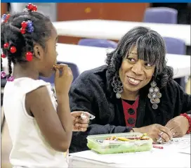  ?? TY GREENLEES / STAFF ?? The Rev. Denise Gilmore listens as Leah Brooks tells her about her school day after arriving at theWesley Center in Dayton. Gilmore is anUnsung Hero who has devoted her life to helping others, particular­ly children in underserve­d areas.