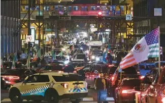  ?? JOHN J. KIM/CHICAGO TRIBUNE ?? Vehicle traffic is stopped on Monroe Street in Chicago’s Loop as large crowds of people celebrate Mexican Independen­ce Day on Friday night. Changes were planned for Saturday night, Police Superinten­dent David Brown said.