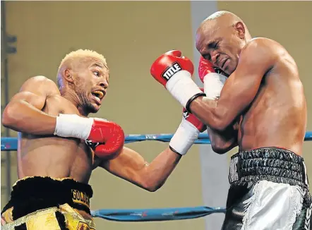  ?? Picture: MARK ANDREWS ?? TAKE THAT: Azinga Fuzile, left, hits his opponent Malcolm Klassen with a left at the Orient Theatre in East London Sunday. Klassen took so much beating that he quit in the fourth round. There was plenty of action for boxing-lovers to savour in the tournament.