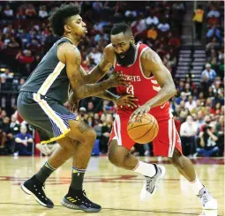  ?? (Reuters) ?? HOUSTON ROCKETS guard James Harden (right) drives to the basket against Golden State Warriors defender Nick Young on Saturday night. In his second game back from injury, Harden scored 22 points, including a crucial three-pointer and a defensive block...