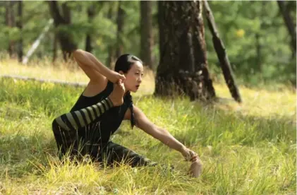  ?? KARL LEUNG ?? YuMee Chung demonstrat­es Archer’s Pose, using her hand to raise her foot and bending her knee as if drawing a bowstring.