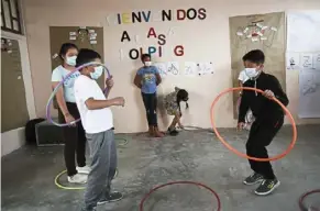  ?? ?? Victor (left) and Eduardo Pacheco participat­ing in a physical education exercise at the start of class at Casa Kolping.