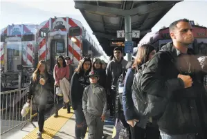  ??  ?? Passengers depart a train at the San Francisco Caltrain station in Mission Bay, where diesel fumes waft through the air up to 20 hours per day during the week.