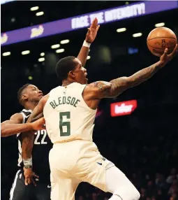  ?? (Reuters) ?? MILWAUKEE BUCKS guard Eric Bledsoe glides to the basket past Brooklyn Nets defender Caris LeVert (22) for two of his game-high 28 points in the second quarter of the Bucks’ 109-94 road victory over the Nets on Sunday night.