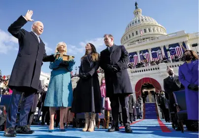  ?? The Associated Press ?? Q Joe Biden is sworn in as the 46th president of the United States by Chief Justice John Roberts, not pictured, as Jill Biden holds the Bible during the 59th Presidenti­al Inaugurati­on at the U.S. Capitol in Washington, Wednesday, as their children Ashley and Hunter watch.