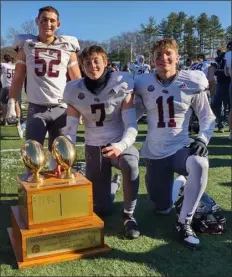  ?? CHRISTOPHE­R HURLEY — LOWELL SUN ?? Westford Academy seniors, from left, Shane Clark, Chris Sell and Nick Russo huddle with the Thanksgivi­ng Day trophy following their 35-10 win over Acton-boxboro.