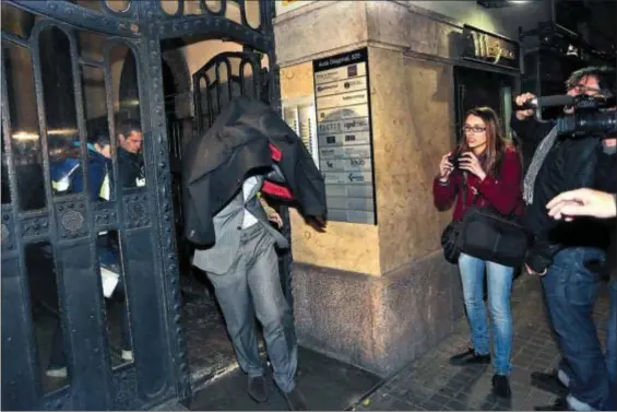  ??  ?? Miembros de la policía escoltan anoche a un exresponsa­ble de Método 3 durante el registro de la agencia ayer en Barcelona. / albert garcía