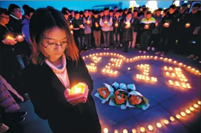  ?? YANG BO / CHINA NEWS SERVICE ?? Students from Dongnan University in Nanjing light candles on Tuesday to commemorat­e the Nanjing Massacre, which began 80 years ago on Wednesday. A memorial hall commemorat­ing the tribunal of accused war criminals in Tokyo will be built in Shanghai.