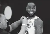  ?? ASSOCIATED PRESS ?? LOS ANGELES LAKERS’ LeBron James smiles as a microphone is placed on his chest during media day at the team’s practice facility Monday in El Segundo, Calif.