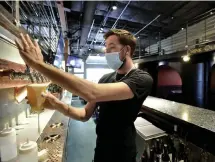  ??  ?? Bartender Branden Weber pours a drink for a customer.