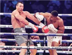  ??  ?? LONDON: Britain’s Anthony Joshua (R) throws a punch at Ukraine’s Wladimir Klitschko during the fourth round of their IBF, IBO and WBA, world Heavyweigh­t title fight at Wembley Stadium. —AFP