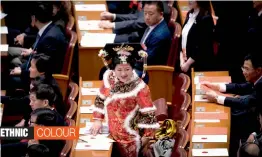  ?? — AP ?? A delegate in ethnic minority costume walks to her seat after casting a vote during a plenary session of China's National People's Congress at the Great Hall of the People in Beijing on Saturday.