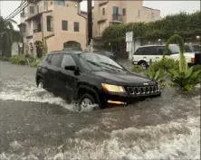  ?? Eugene Garcia/Associated Press ?? A motorist makes their way along a flooded street Thursday as rain falls in Santa Barbara, Calif.