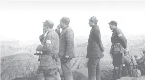  ??  ?? 彭德怀（左二）、习仲勋（右二）等指挥员在青化砭战地­前线勘察地形