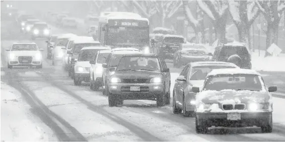  ?? DARREN STONE, TIMES COLONIST ?? Traffic moves through afternoon snow along Cook Street.