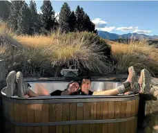  ??  ?? Bridget and Bevan Newlands sit in the 400-litre cedar bath tub outside the lodge.