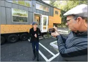  ??  ?? Eric Wood takes a video of his wife, Lindsay, as she gives an update of their status in front of their 300-squarefoot mobile tiny home in the parking lot of the San Ramon Marriott in San Ramon on Tuesday.