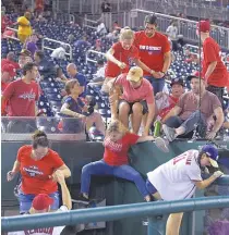  ?? AP PHOTO ?? Fans jump into a camera well after hearing gunfire from outside the stadium during a baseball game between the San Diego Padres and the Washington Nationals at Nationals Park in Washington on July 17, 2021 (July 18 in Manila).
