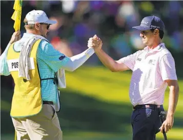  ?? CHARLIE NEIBERGALL AP ?? J.T. Poston celebrates with his caddie on the 18th green after winning the John Deere Classic.