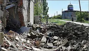  ?? ANDRIY ANDRIYENKO / AP ?? A crater of an explosion after Russian shelling is seen next to a damaged apartment building in Bakhmut, Donetsk region, Ukraine, Thursday.