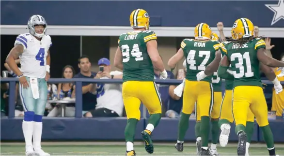  ?? AP) (Photo by Michael Ainsworth, ?? Dallas Cowboys quarterbac­k and former Mississipp­i State player Dak Prescott (4) watches the Green Bay Packers celebrate a touchdown on Sunday.