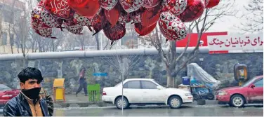  ?? Associated Press ?? ↑
A boy selling Valentine’s Day balloons waits for customers in Kabul on Thursday.