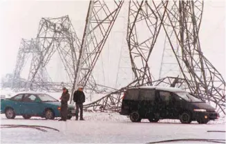  ?? JACQUES BOISSINOT ARCHIVES LA PRESSE CANADIENNE ?? Des automobili­stes observent des pylônes endommagés près de Saint-Bruno-de-Montarvill­e.