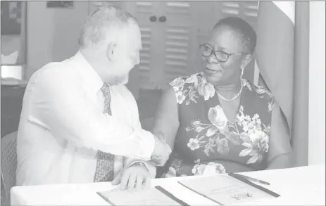  ??  ?? National Hydrograph­er of the UK Hydrograph­ic Office, Rear Admiral Tim Lowe, and the Director General of the Maritime Administra­tion Department, Claudette Rogers shake hands shortly after signing the data release statement. (Department of Public Informatio­n photo)