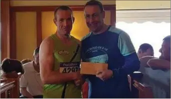  ??  ?? Peter Hearty collecting his prize for third place in the Longwood 5k.