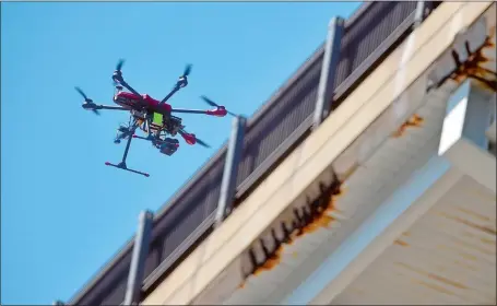  ?? TIM MARTIN/THE DAY ?? An Align M690L unmanned aerial vehicle owned and operated by Exponent Technology Services flies Tuesday alongside the northbound side of the Gold Star Memorial Bridge to photograph and record video to be used for bridge inspection. The inspection...