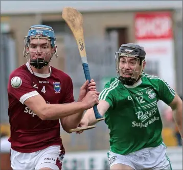  ??  ?? Eoin Conroy of Naomh Eanna attempts the hook as Conor Firman (St. Martin’s) prepares to clear.