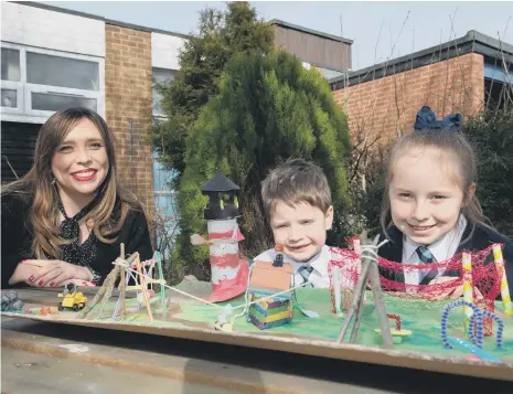  ??  ?? Councillor Rebecca Atkinson with competitio­n winners Sophia and Henry Nixon and their 3D design of the new play park.