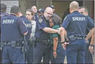  ?? AP/Houston Chronicle/JON SHAPLEY ?? Law enforcemen­t officers and others mourn Friday after escorting the body of Deputy Sandeep Dhaliwal to Houston’s Harris County Institute of Forensic Sciences.