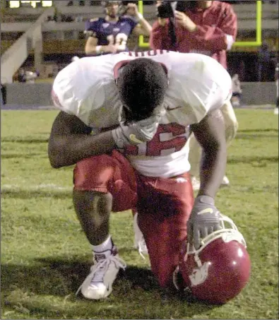  ?? Democrat-Gazette file photo ?? Arkansas linebacker Raymond House pauses to pray after the Razorbacks’ 58-56, seven-overtime victory over Mississipp­i in 2001 at Vaught-Hemingway Stadium in Oxford, Miss. It was the longest NCAA game ever played. The Razorbacks equaled the mark two...