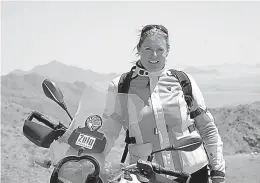  ?? Associated Press ?? BELOW: This October 2014 photo provided by Alisa Clickenger shows Clickenger posing with her motorcycle in Namibia. Clickenger operates Women’s Motorcycle Tours, which conducts motorcycle rides that cater exclusivel­y to women. She estimates that she’s...