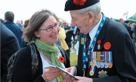  ?? CP FILE PHOTO ?? Julia Mackey presents a copy of her play Jake’s Gift to D-Day veteran William Davis at the Juno Beach Centre in Normandy, France on June 5, 2014.