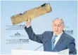  ?? FOTO: DPA ?? Hält ein Stück einer abgeschoss­enen Drohne hoch: der israelisch­e Ministerpr­äsident Benjamin Netanjahu.