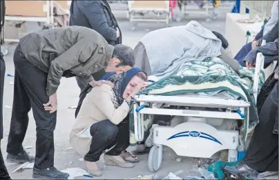  ?? AP PHOTO ?? Relatives weep over the body of an earthquake victim in Sarpol-e-Zahab, western Iran, Monday. Authoritie­s reported a powerful 7.3 magnitude earthquake struck the Iraq-Iran border region on Monday and killed more than 400 people in both countries.