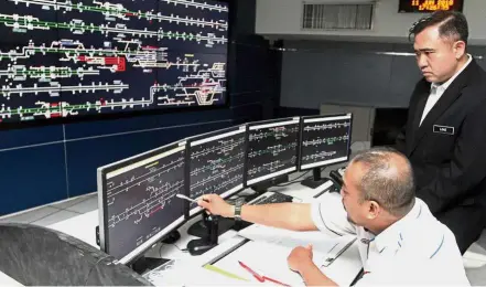  ??  ?? Right on track: Loke visiting the KTMB Controller Department at KL Sentral after distributi­ng gifts to passengers boarding at KTM KL Sentral in Kuala Lumpur. Indicating at the computer monitor is KTMB train control officer Saiful Bahari Abd Rahman.