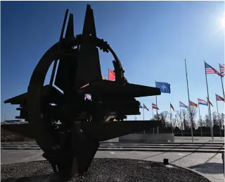  ?? Photo by JOHN THYS / AFP ?? This photograph taken on February 27, 2024 shows an empty mast amongst member nation flags in the Cour d’Honneur of the NATO headquarte­rs, ahead of a flag-raising ceremony for Sweden’s accession to NATO, in Brussels on February 27, 2024.