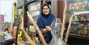  ??  ?? BERAWAL DARI HOBI: Jajuk memperliha­tkan kerajinan glass painting hasil ketelatena­nnya. MUHAMMAD HAFIS IQBAL/RADAR KANJURUHAN