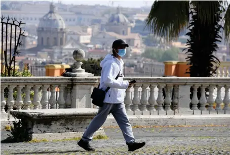  ?? Reuters ?? A man wearing a protective face mask walks, as the spread of the coronaviru­s disease (COVID-19) continues in Rome, Italy.